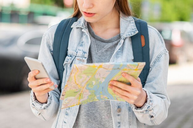 地図と携帯電話を持つ旅行者