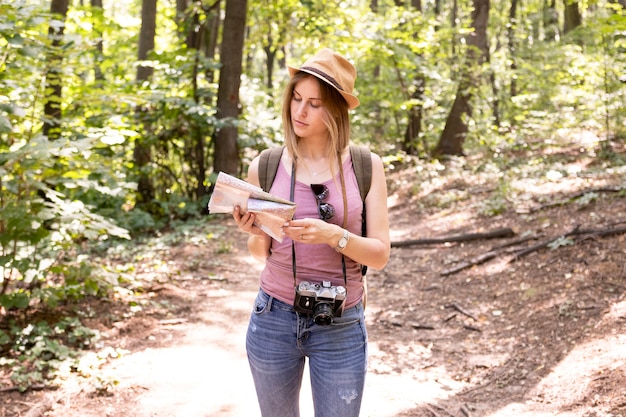 Traveller in woods looking at map