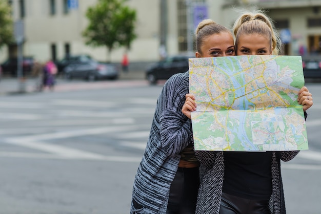 Free photo travellers hiding behind map