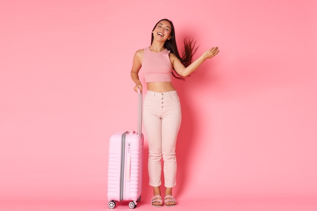 旅行、休日、休暇のコンセプト。のんきで生意気なアジアの女の子の観光客は海外に行くためにバッグを詰めました