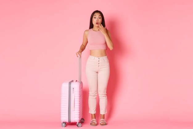 Travelling, holidays and vacation concept. Surprised and gasping cute asian girl in summer clothes