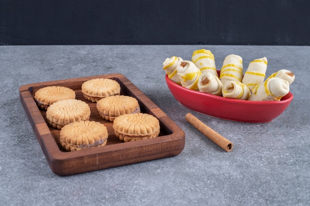 Free photo a tray of biscuits and a bowl of cookie wrappings