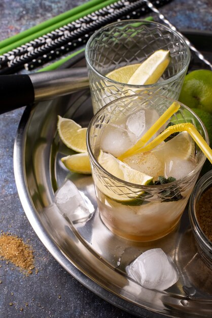 Tray of cocktail glasses with ice and lime