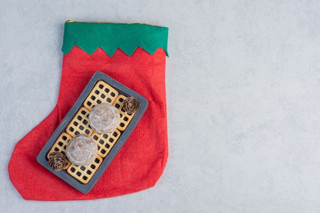 Tray cookies and biscuits on a christmas stocking on marble surface