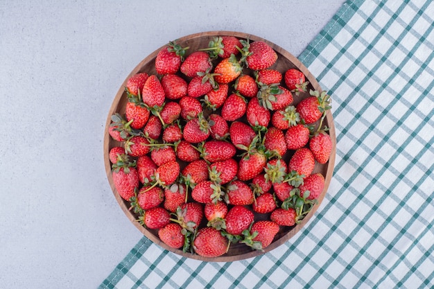 Tray full of strawberries on marble background.