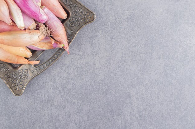 A tray of ripe onion, on the marble surface