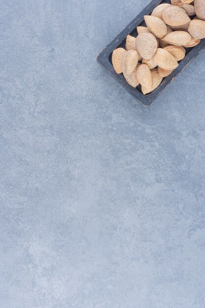 A tray of tasty almonds , on the marble background. 