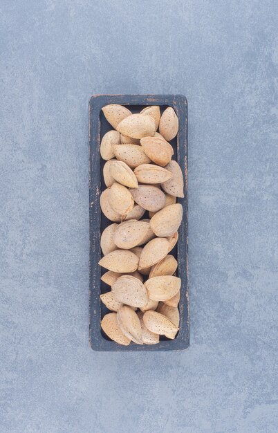 A tray of tasty almonds , on the marble background. 