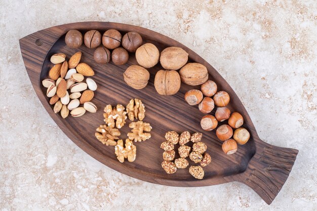 Tray with assorted nuts and chocolate balls on marble