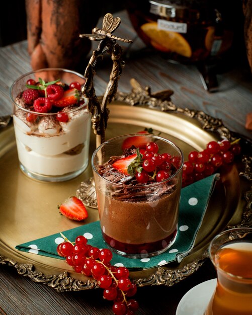 Поднос с двумя стаканами тирамису и шоколадным пудингом с ягодами _