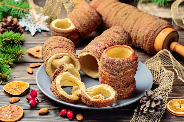 Trdelnikは 砂糖 シナモン バニラを使った唾と木炭の生地で焼いた珍味です クリスマスのお菓子 屋台の食べ物 チェコ料理とモラヴィア料理 プレミアム写真 Trdelnikは 砂糖 シナモン バニラを使った唾と木炭の生地で焼いた珍味です クリスマスのお菓子 屋台の食べ物 チェコ料理とモラヴィア料理 プレミアム写真
