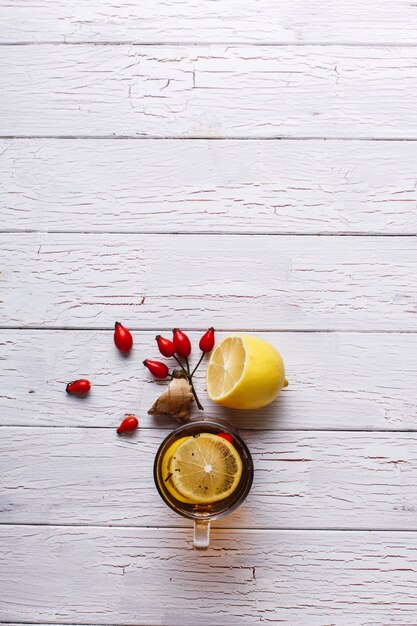 감기 치료. 레몬과 딸기와 함께 뜨거운 차는 흰색 나무 테이블에 서