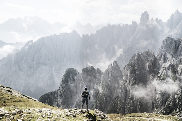 Trekker with a backpack enjoying foggy mountain view