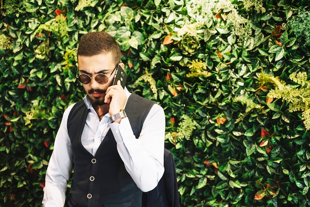Модный бизнесмен говорить по телефону в кафе