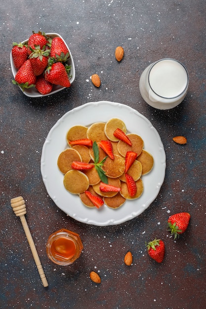 Trendy food - mini pancake cereal. Heap of cereal pancakes with berries 