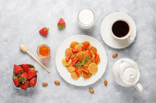 Trendy food - mini pancake cereal. Heap of cereal pancakes with berries