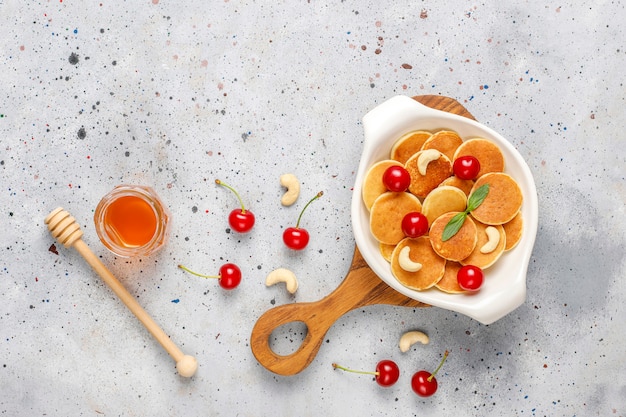 Cibo alla moda - cereali mini pancake. mucchio di frittelle di cereali con frutti di bosco