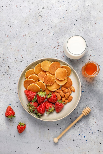 Бесплатное фото Модная еда - мини блинная каша. куча зерновых блинов с ягодами и орехами.