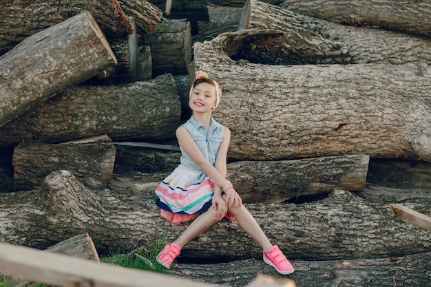 Free photo trendy girl sitting on a log