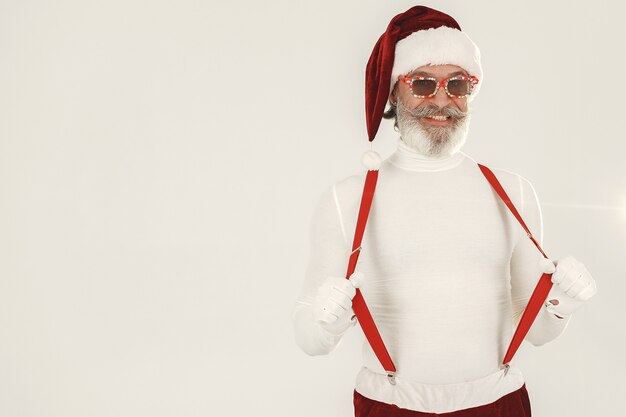 Trendy grey-haired santa. Man wear knitted clothes. Grandfather in a santa's hat.