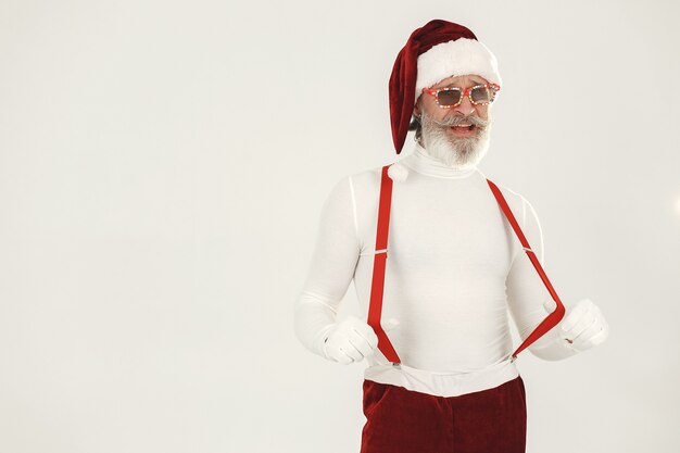 Foto gratuita babbo natale dai capelli grigi alla moda. l'uomo indossa vestiti a maglia. nonno in un cappello di babbo natale.