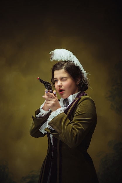 Бесплатное фото Модный женский портрет эпохи возрождения с пистолетом