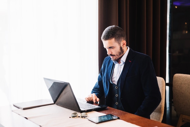 trendy man at table with gadgets