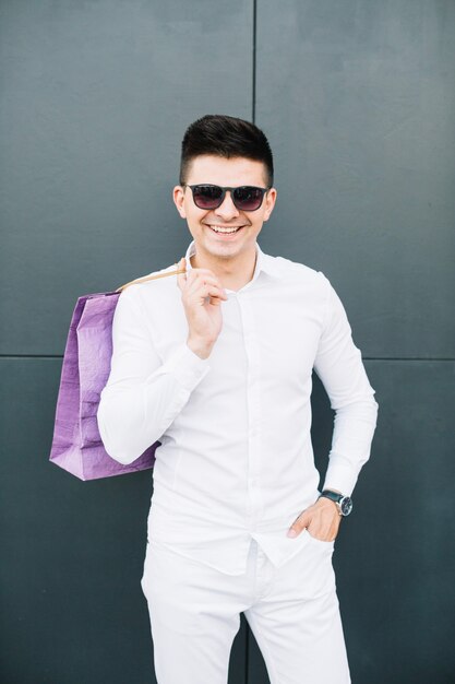 Trendy man in white with paper bag
