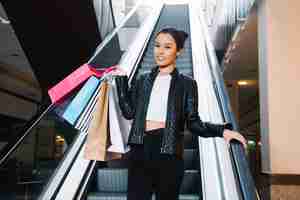 Free photo trendy model holding pile of paper bags