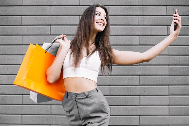 Trendy model taking selfie with purchases