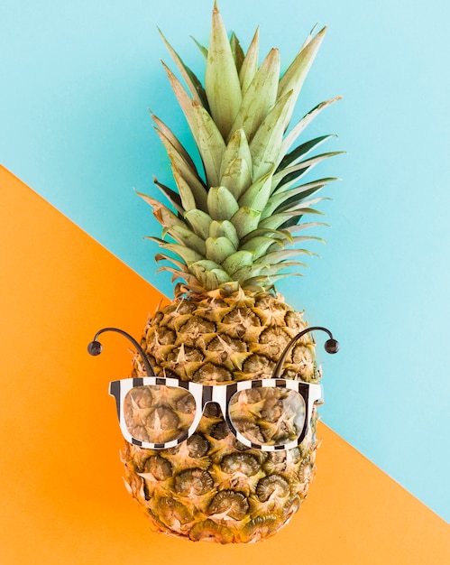 Trendy pineapple in sunglasses on multicolored background