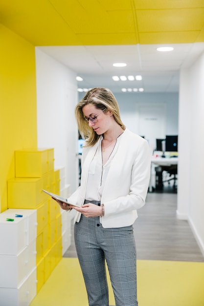 Trendy woman in office with tablet