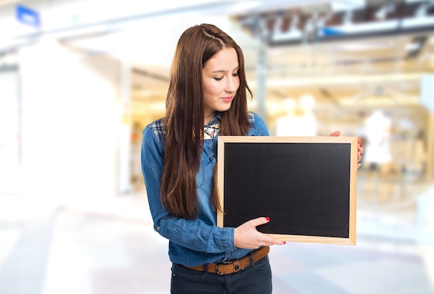 Trendy young woman holding a black board