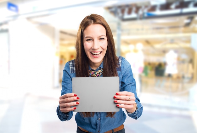 Trendy young woman looking happy holding a grey card