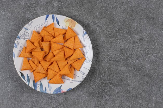 Triangle shaped crackers on colorful plate.