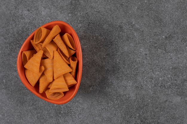 Triangle shaped crackers in orange bowl.
