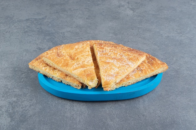 Triangle shaped pastries on blue plate. 