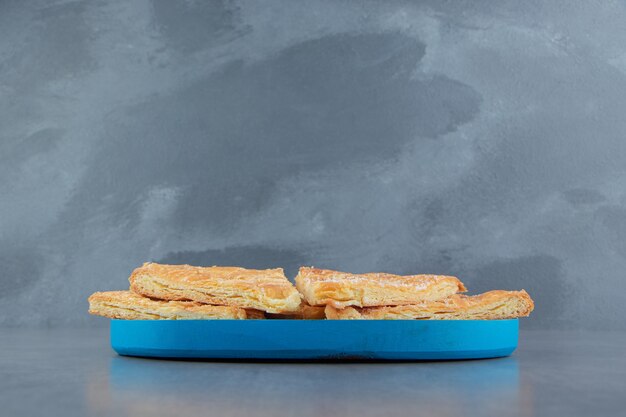 Free photo triangle shaped pastries on blue plate.