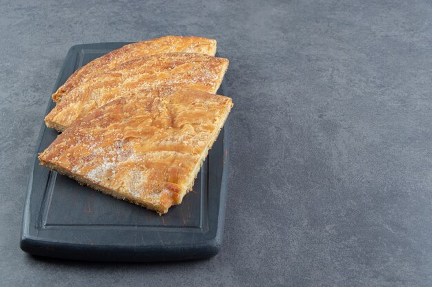 Triangle shaped pastries on dark board. 