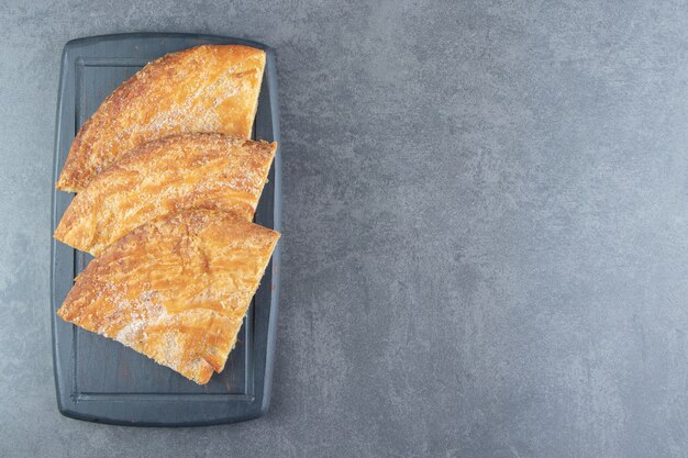 Triangle shaped pastries on dark board. 