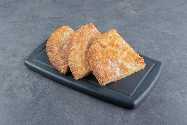 Triangle shaped pastries on dark board. 