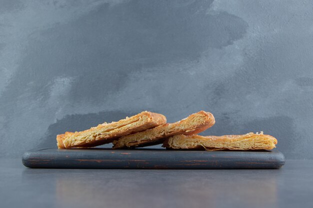 Triangle shaped pastries on dark board.