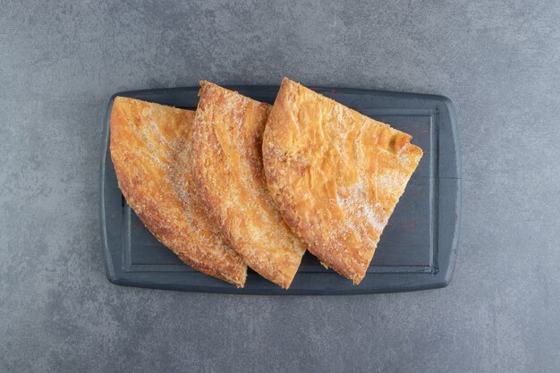 Triangle shaped pastries on dark board.