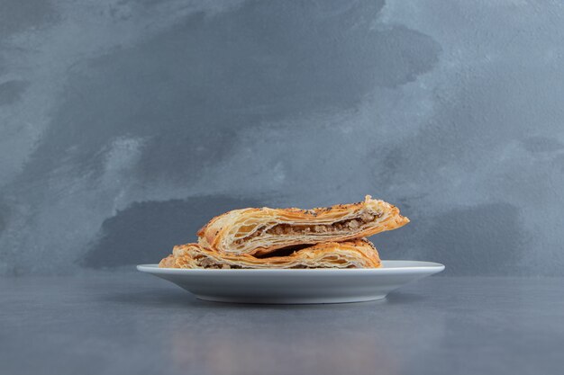 Triangle shaped pastries filled with meat on white plate.