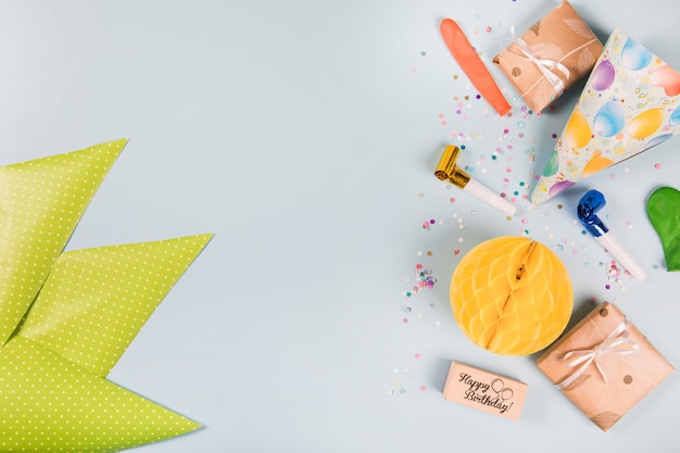 Triangular green paper and party items on gray background