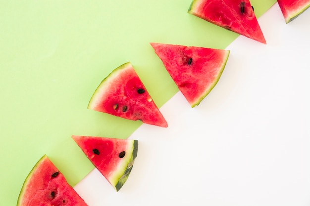 Free photo triangular shape of watermelon slices on dual background