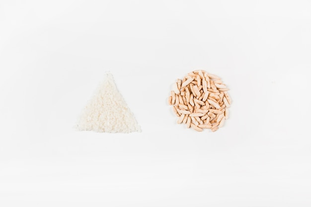 Triangular white rice and circular puffed rice on white background