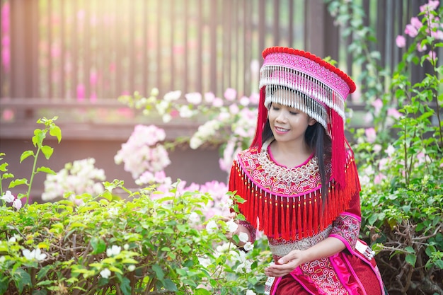 公園の赤い伝統的な衣装で部族の美しい女性