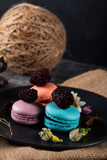 Tricolor French macarons in a black saucer