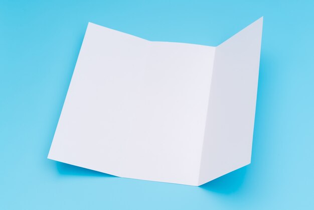 Trifold white template paper on blue background .